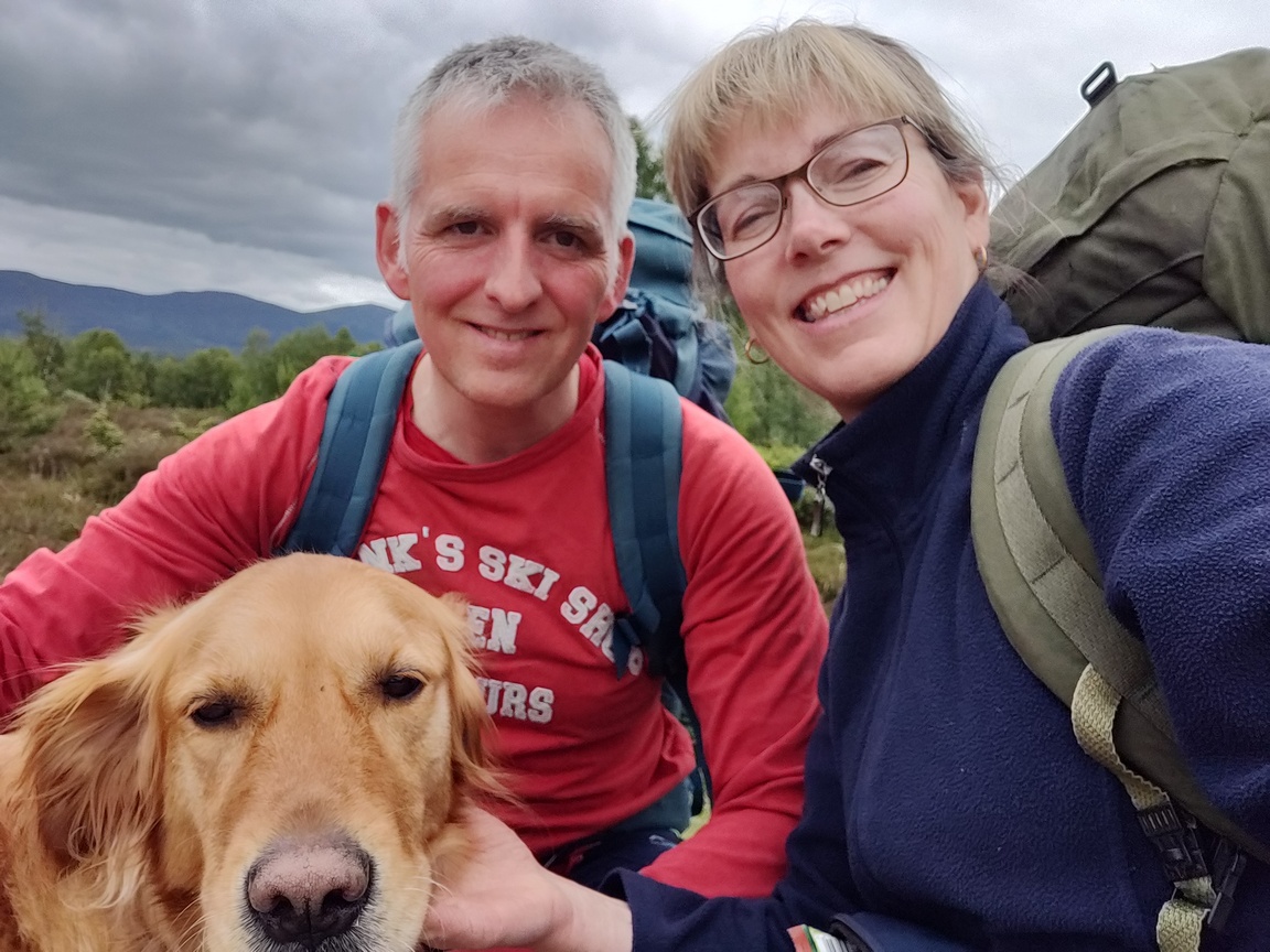 Man & woman with backpacks and dog