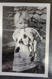 Little girl holding baby goat
