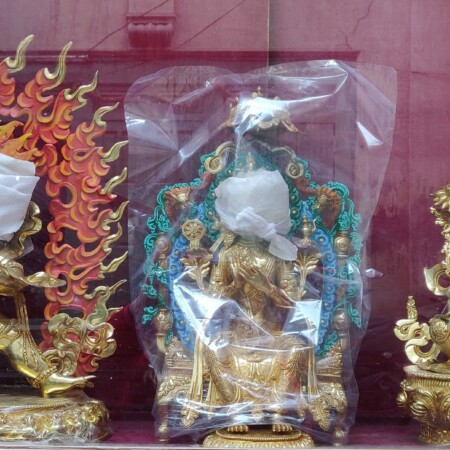 three gold idols with faces wrapped in cloth