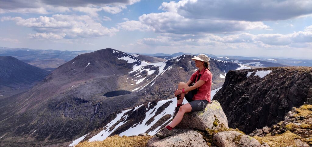 Photo of Merryn Glover in shorts & hat sitting on the mountain of Braeriach in the Cairngorms - Credit: Alistair Appleby