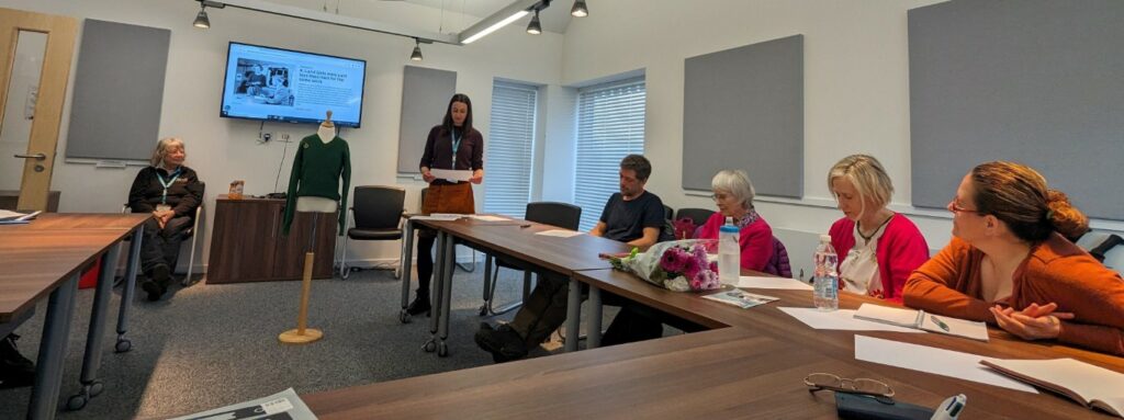 woman presents Womens Land Army jumper to workshop participants