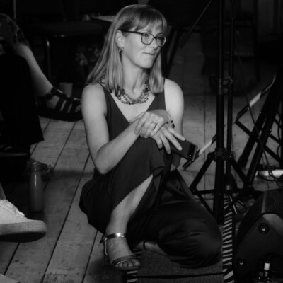 A woman kneeling on the floor smiling at a scene off camera