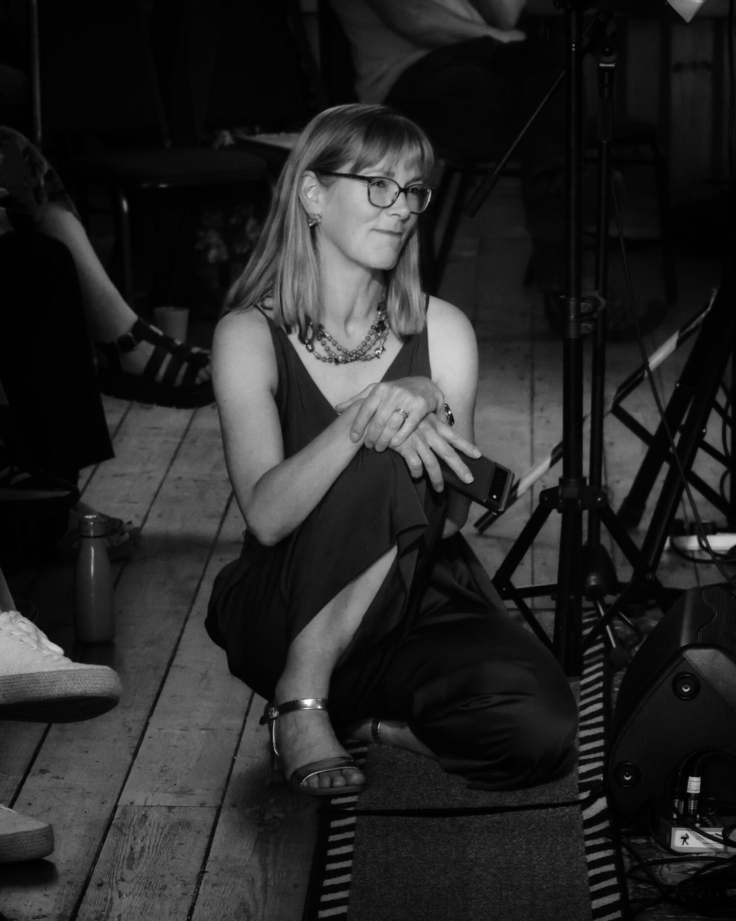 A woman kneeling on the floor smiling at a scene off camera